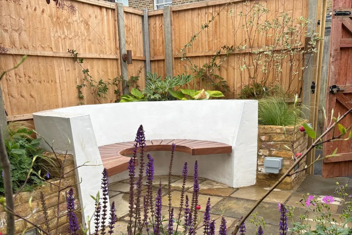 Rendered curved bench with a timber seat, brick raised beds and riven stone paving